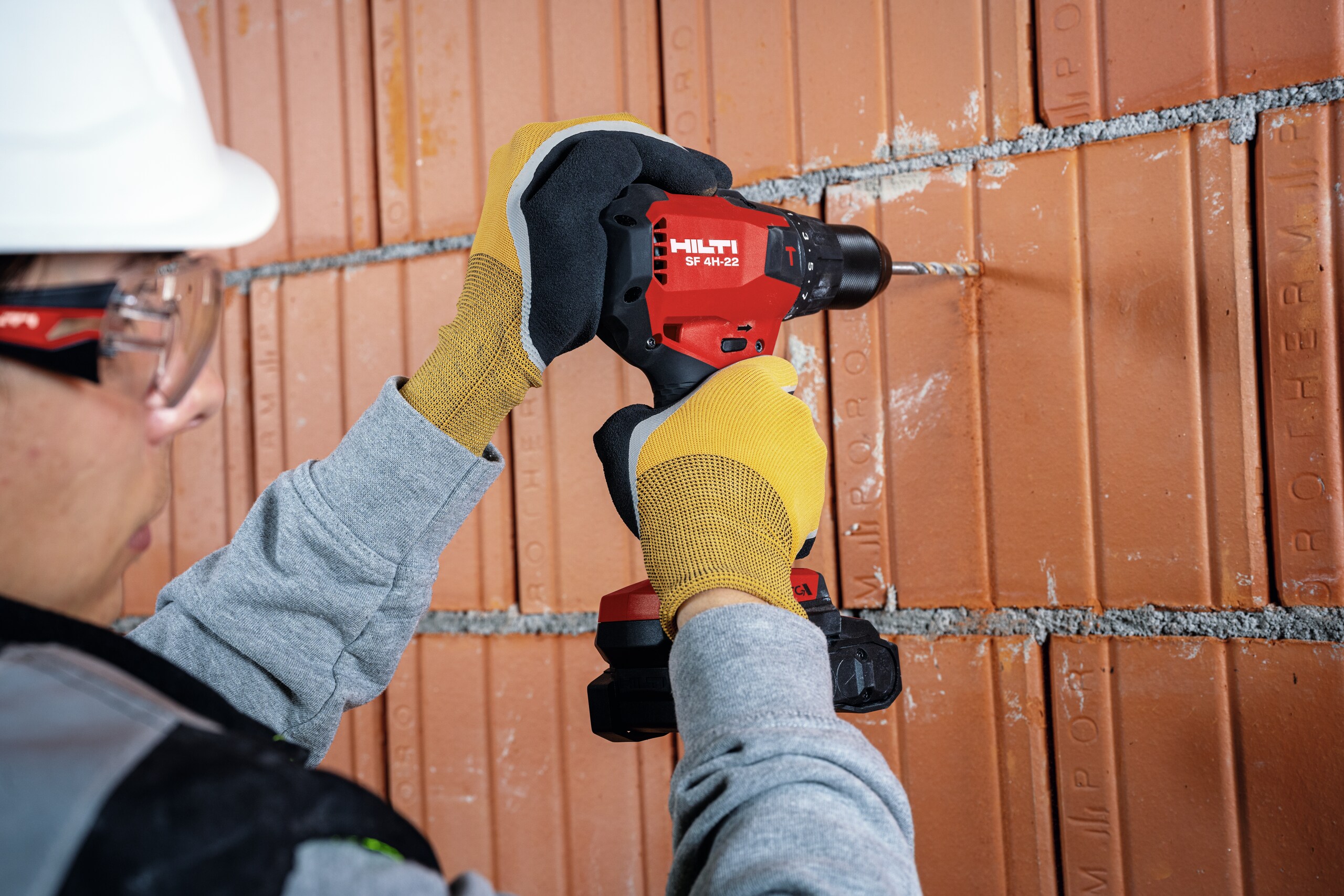 Trabajador perforando una pared de ladrillo con la SF 4H-22
