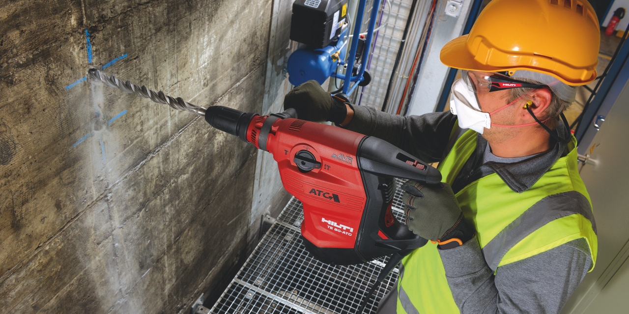 Trabajador de la construcción utilizando un martillo combinado con cable TE 80-ATC/AVR con Control activo de par (ATC) que ayuda a evitar el retroceso