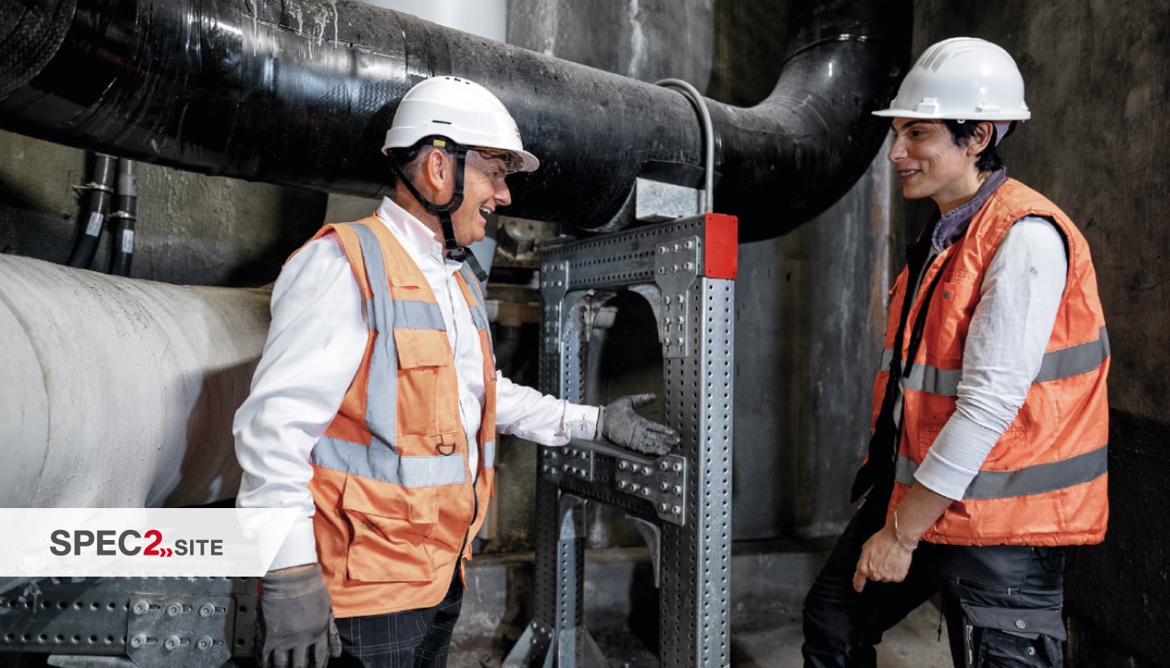 Un ingeniero de Hilti y un cliente inspeccionan un sistema de soporte modular para tuberías.